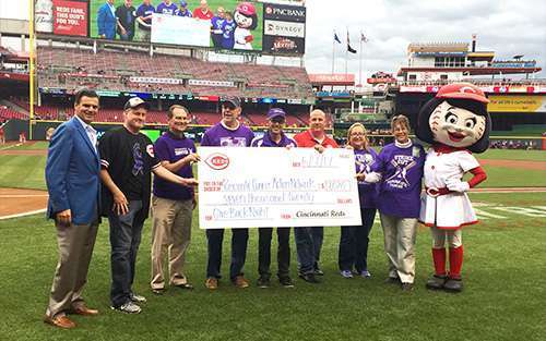 Cincinnati Affiliate volunteers stand on the Reds’ Great American Ball Park field as they present a donation check for $7,020