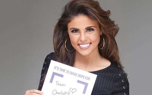 Miss Louisiana holds a Wage Hope sign for her PurpleStride team in honor of her grandmother