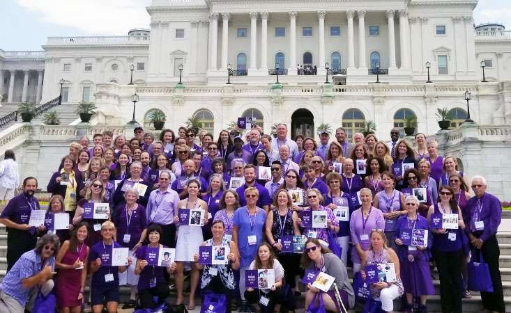 Pancreatic cancer advocates dressed in purple stand in front of the United States Capitol.