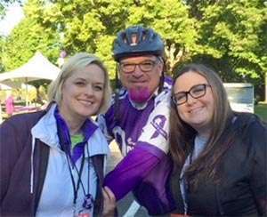 Longtime pancreatic cancer survivor with her husband and daughter at PurpleRideStride event
