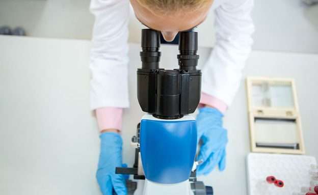 Feature image A pancreatic cancer researcher examines cancer cells under a microscope