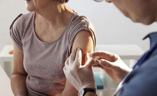 Feature image A pancreatic cancer caregiver gets flu shot from doctor