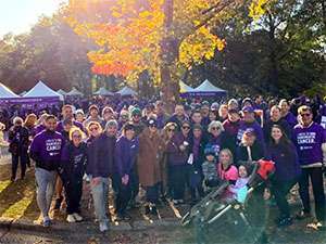 Couple with friends and family at PurpleStride Atlanta 5K walk a few hours before their wedding