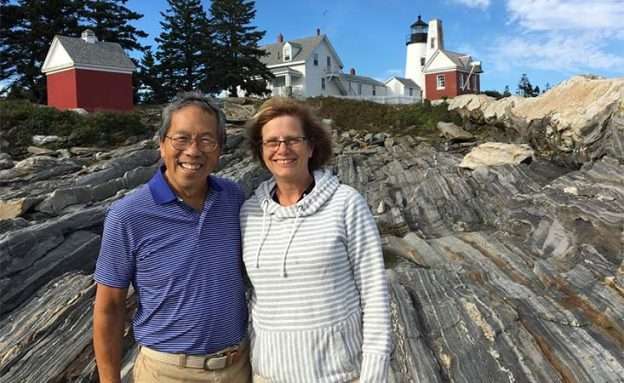 Pancreatic cancer caregiver and her husband in front of a lighthouse in Maine during vacation
