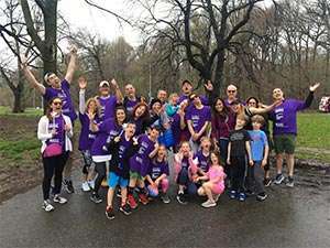 Stage IV pancreatic cancer survivor with team at PanCAN's PurpleStride New York City walk