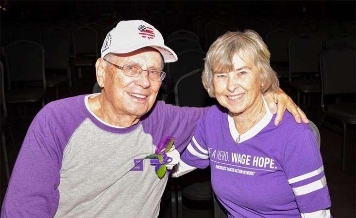 Stage IV pancreatic cancer survivor and his wife wearing purple PanCAN t-shirts
