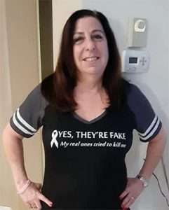 Full-length shot of woman in breast cancer survivor T-shirt.