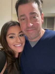 Father and daughter posing for a picture.