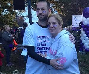 Middle-aged Caucasian couple embracing at outdoor fundraising event
