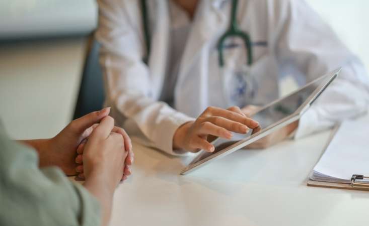 Feature image doctor with tablet talking to patient
