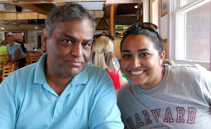 Feature image Paula Mukherjee (right) with her dad Sanjib (right), sitting in a booth at a restaurant smiling.