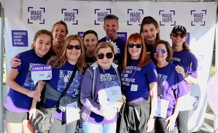 People smiling at a PanCAN PurpleStride event.