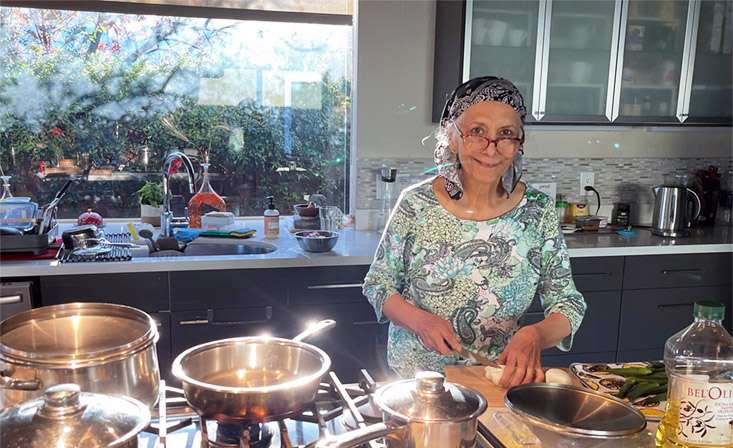 Feature image Syeda "Naz" Nazar cooking in her kitchen.