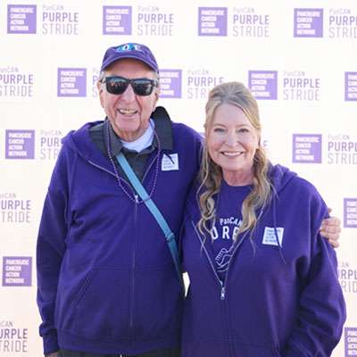 Lisa Niemi Swayze (R), with Eric Idle (L), posing for photo at PanCAN PurpleStride Los Angeles 2024.