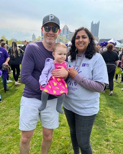 A man and a woman holding a baby at PanCAN PurpleStride Pittsburgh.
