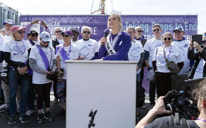 Miss America Madison Marsh on stage with pancreatic cancer survivors at PanCAN PurpleStride New York City 2024.