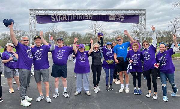 Ten people standing in front of the finish line at PanCAN PurpleStride Chicago 2024.